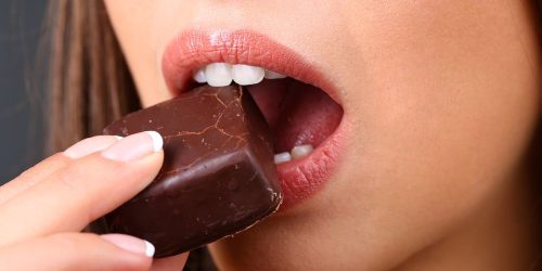 women biting chocolate