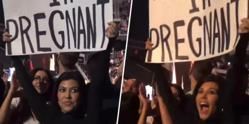 Kourtney Kardashian holds up a sign announcing her pregnancy.