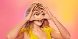Taylor Swift making a heart with her hands and looking through it after making changes to eras tour